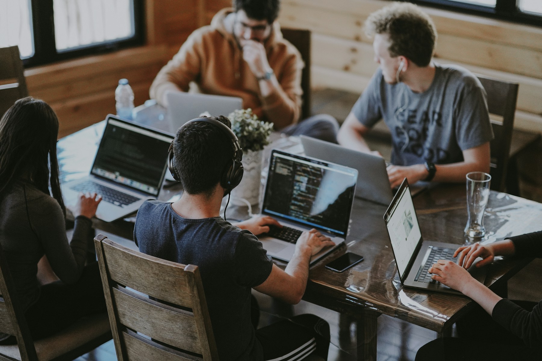 A digital team collaborating around laptops